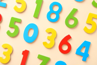 Photo of Colorful numbers on beige background, flat lay