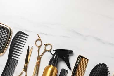 Hairdressing tools on white marble table, flat lay. Space for text