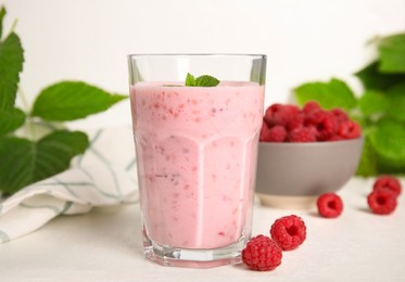 Photo of Glass of tasty raspberry smoothie on white table