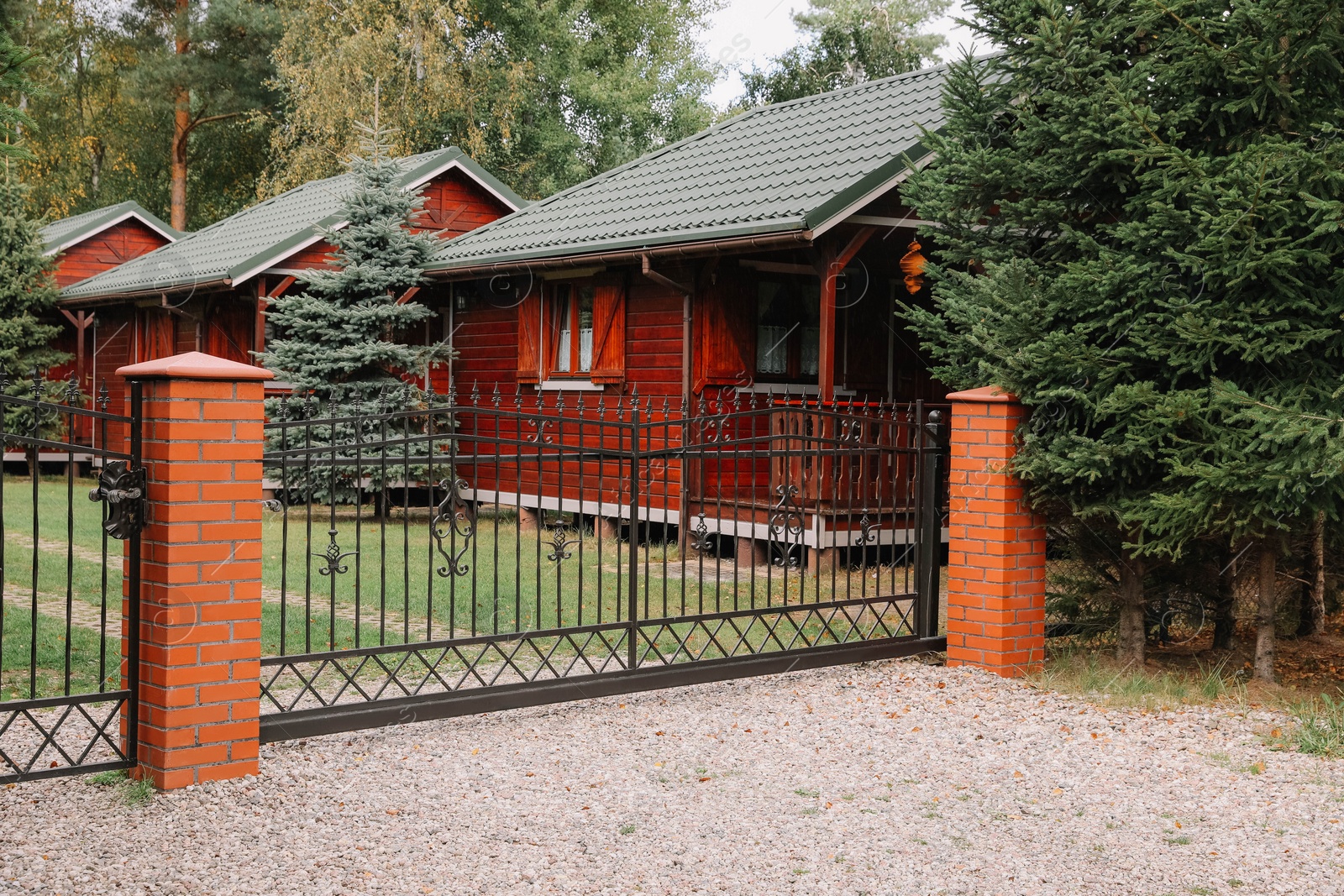 Photo of Closed metal gates near beautiful garden and houses outdoors