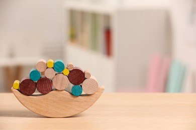 Photo of Wooden balance toy on table indoors, closeup. Space for text. Children's development