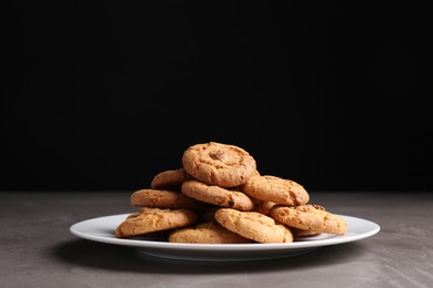 Photo of Tasty cookies on grey textured table, closeup