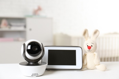 Baby monitor with camera and toy on table in room. Video nanny