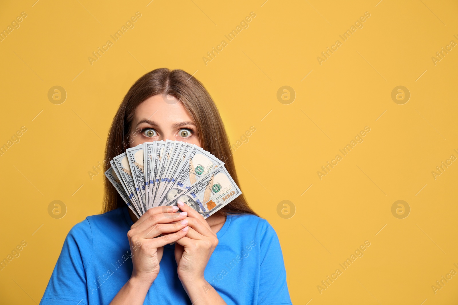 Photo of Portrait of happy lottery winner with money on yellow background, space for text