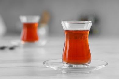 Photo of Glass of traditional Turkish tea on white marble table, space for text