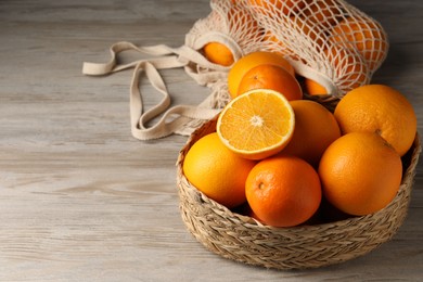 Many whole and cut oranges on wooden table. Space for text