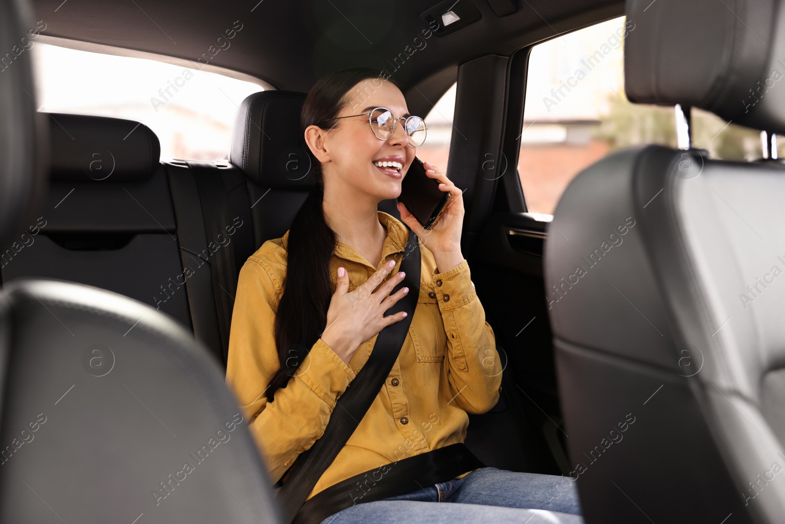 Photo of Woman with seatbelt talking on phone inside car