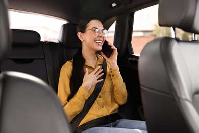 Photo of Woman with seatbelt talking on phone inside car