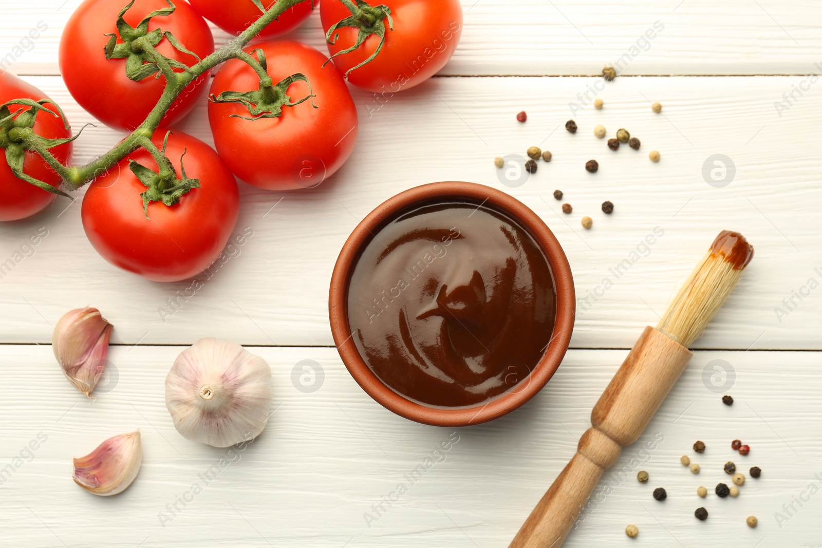 Photo of Flat lay composition with tasty barbeque sauce in bowl on white wooden table