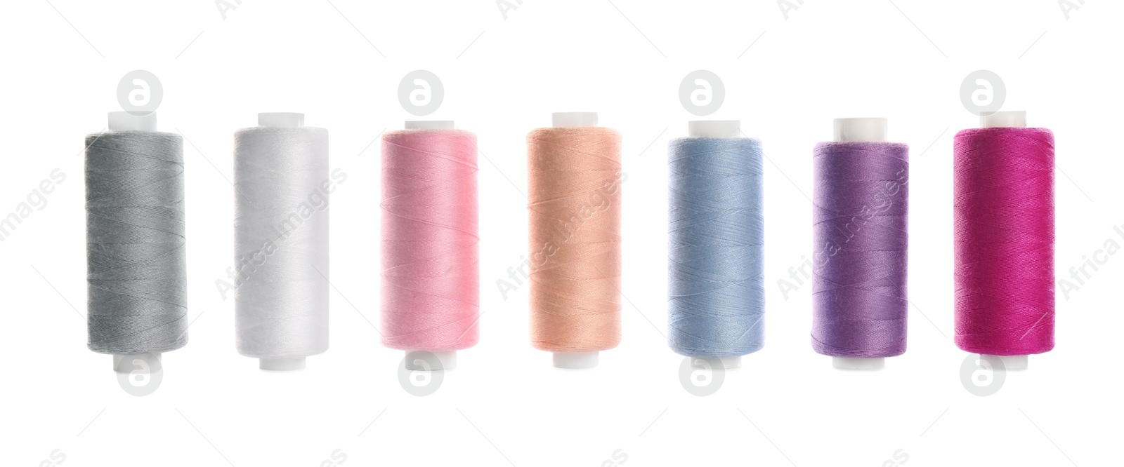 Photo of Set of colorful sewing threads on white background