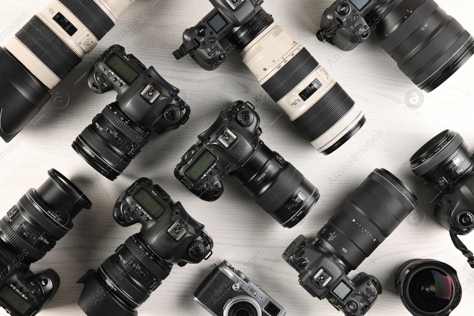 Photo of Modern cameras on white wooden table, flat lay