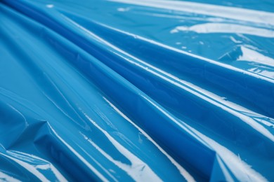 Photo of Closeup view of light blue plastic stretch wrap film as background