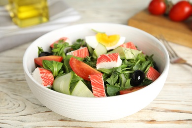 Delicious crab stick salad served on wooden table