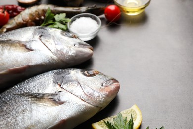 Photo of Fresh raw dorado fish on light grey table, closeup. Space for text