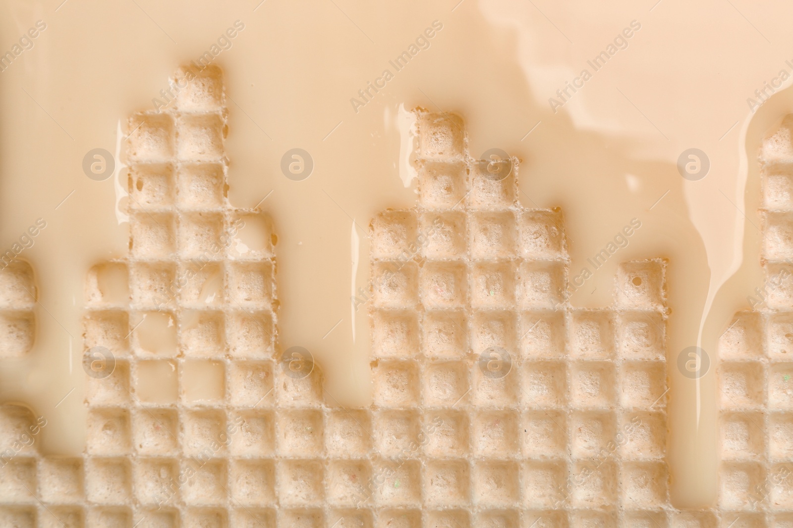 Photo of Hot white chocolate on wafer, closeup. Crispy food