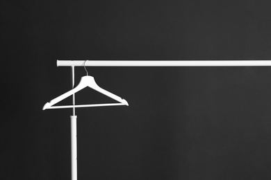 Photo of Wardrobe rack with hanger against dark background