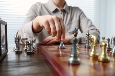 Woman playing chess during tournament at table, closeup