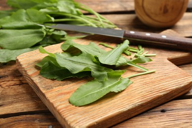 Photo of Fresh cut sorrel leaves on wooden table, closeup