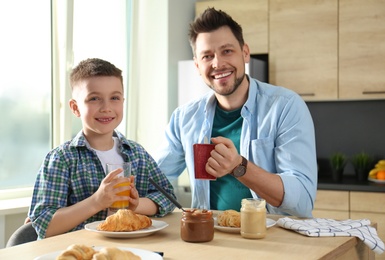 Dad and son having breakfast together in kitchen