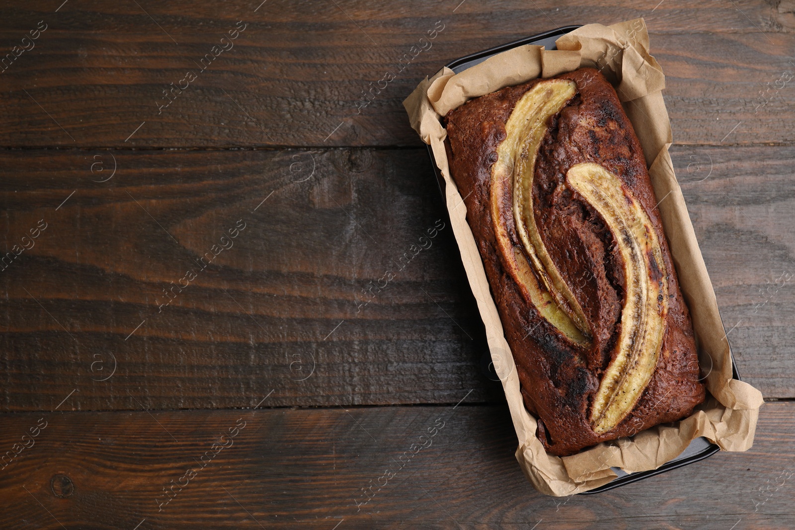 Photo of Delicious banana bread on wooden table, top view. Space for text