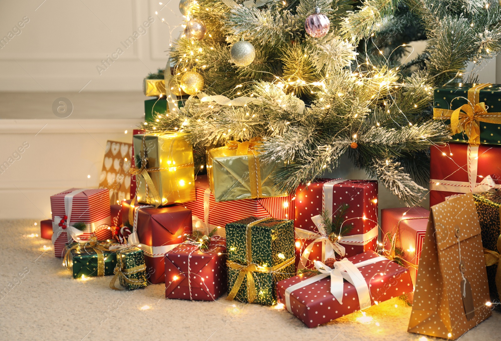 Photo of Many different gifts under Christmas tree indoors