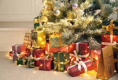 Many different gifts under Christmas tree indoors