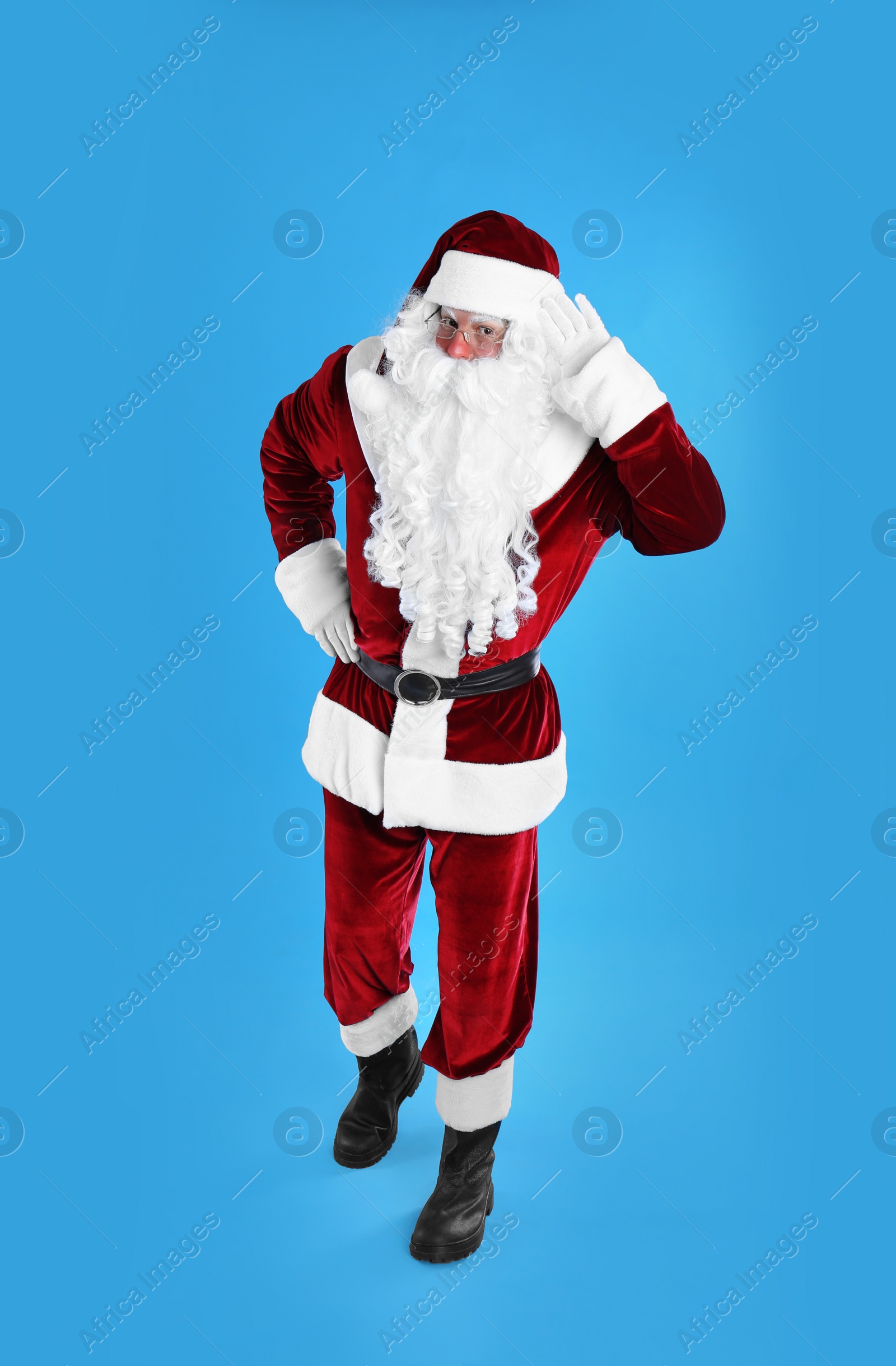 Photo of Full length portrait of Santa Claus on light blue background