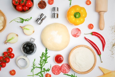 Photo of Dough and ingredients for pizza on white background, top view