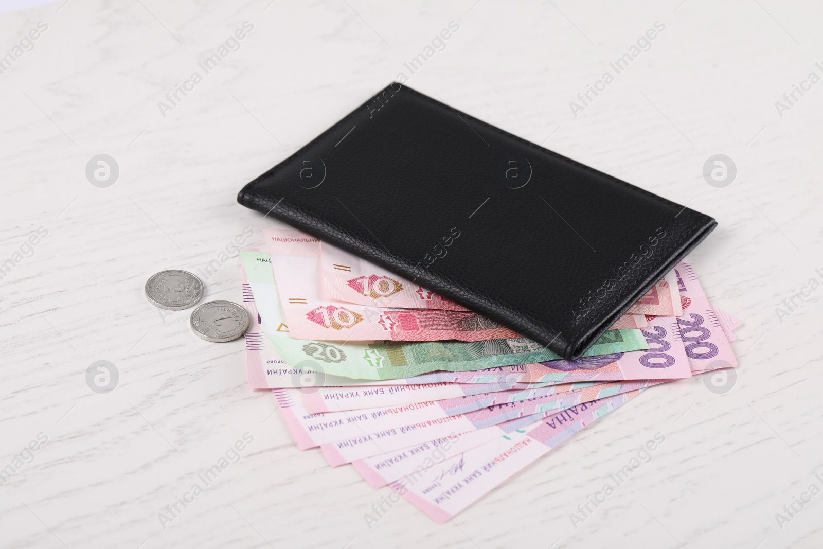 Photo of Pension certificate with Ukrainian money on white wooden background