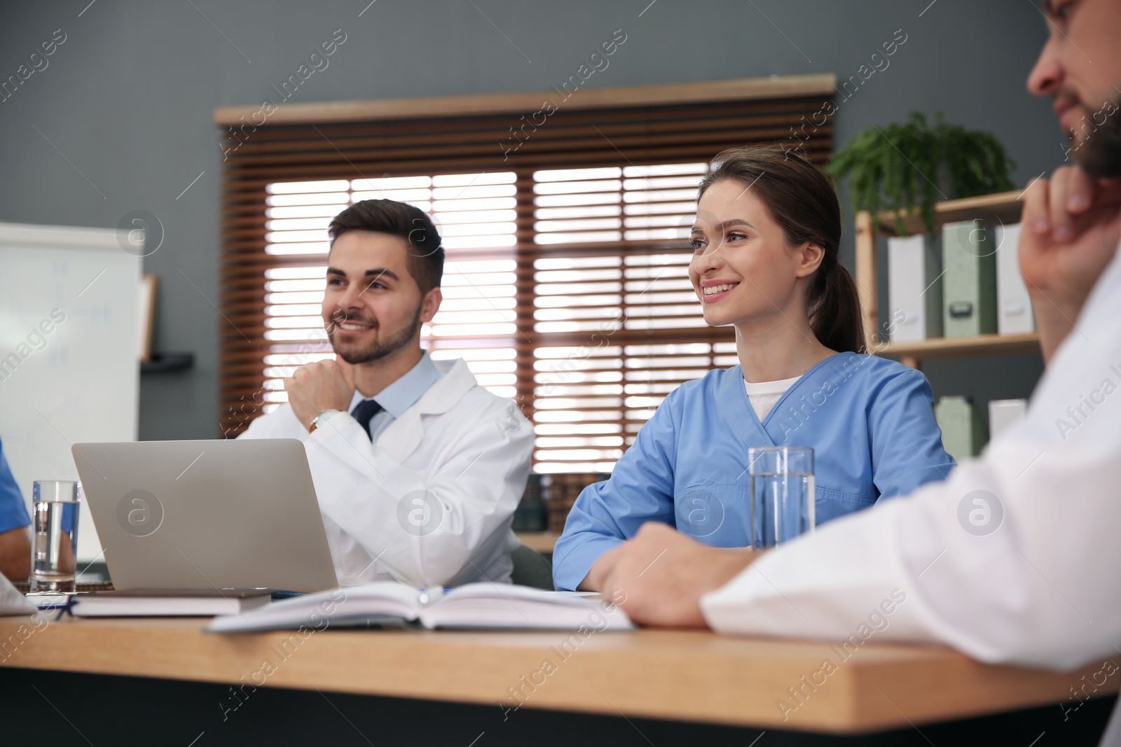 Photo of Team of professional doctors having meeting in office