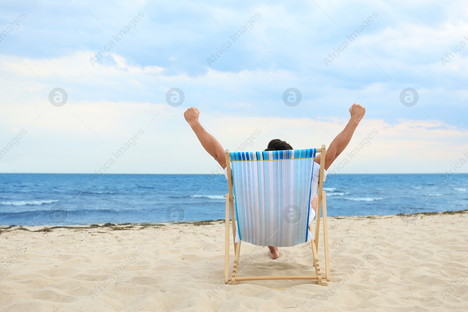 Photo of Man relaxing in deck chair on sea beach