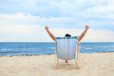 Photo of Man relaxing in deck chair on sea beach