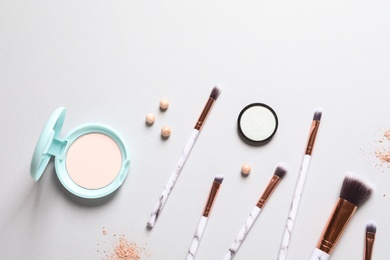 Flat lay composition with makeup brushes on grey background