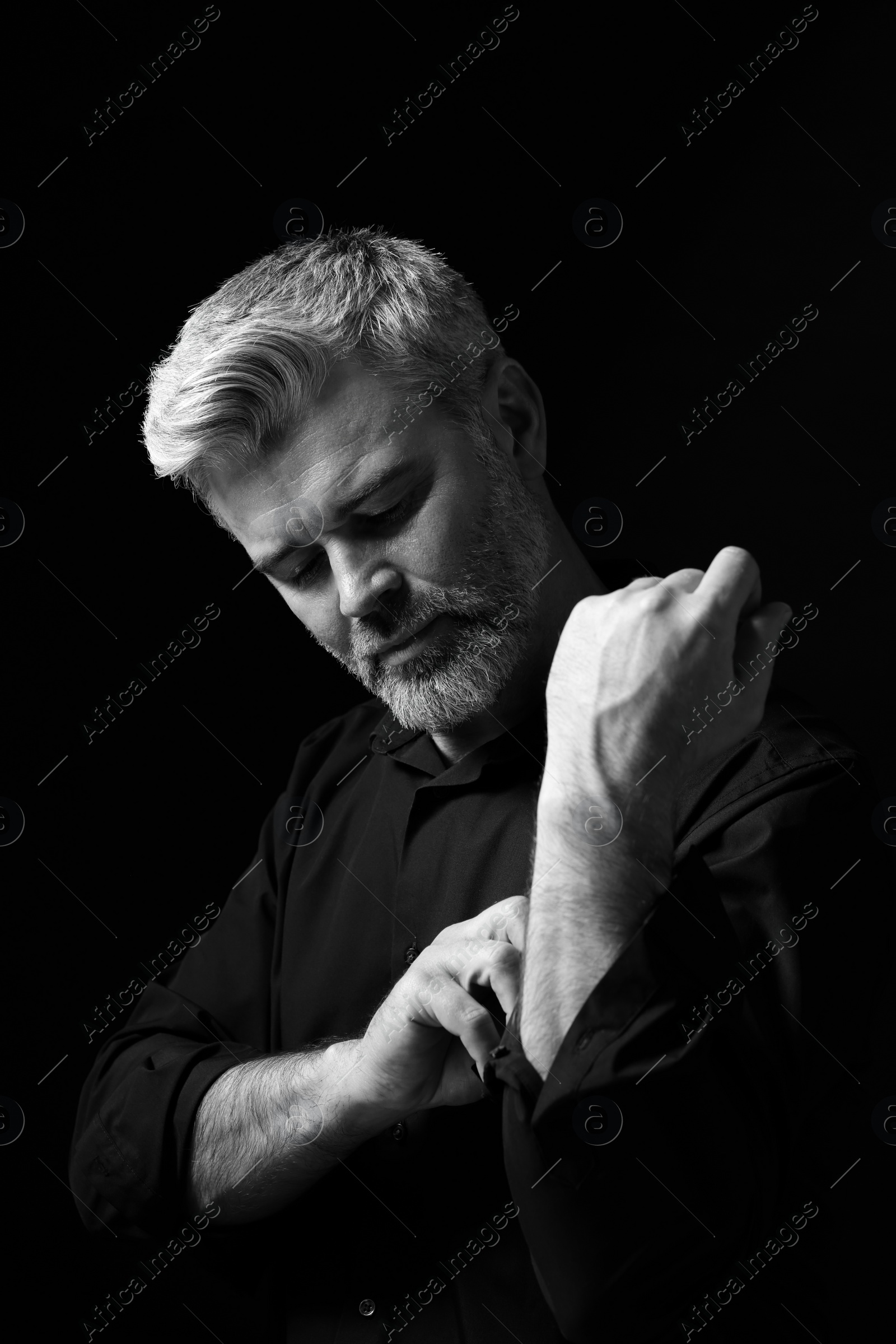 Photo of Portrait of handsome man on dark background. Black and white effect