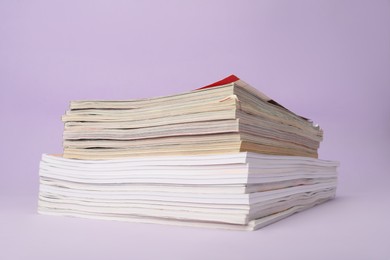 Group of stacked magazines on violet background