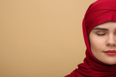 Muslim woman in hijab on beige background, space for text