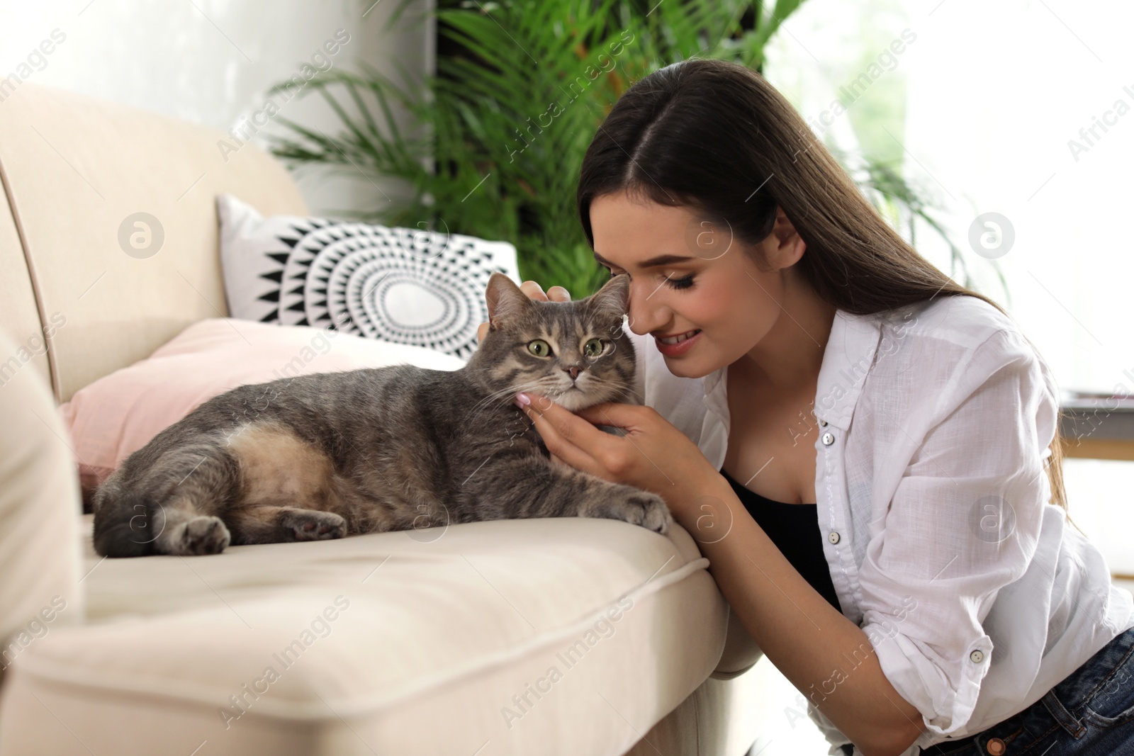 Photo of Young woman with cute cat at home. Pet and owner