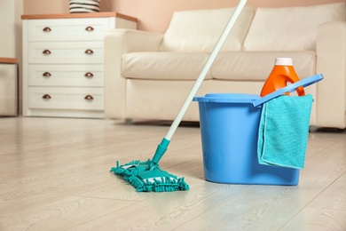 Photo of Cleaning supplies on floor in living room. Space for text