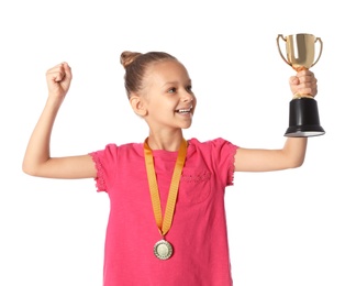 Happy girl with golden winning cup and medal on white background