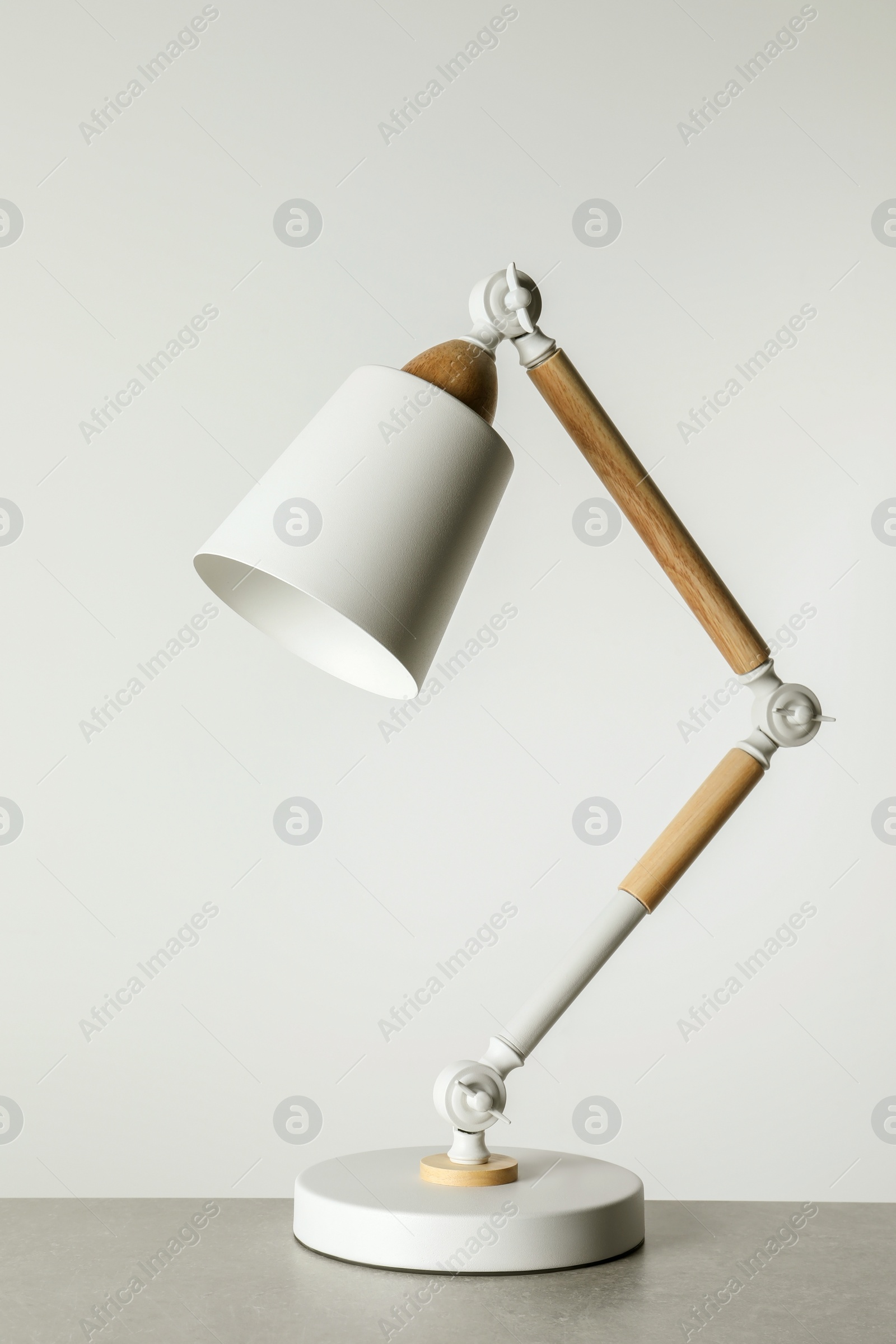 Photo of Stylish modern desk lamp on light gray table