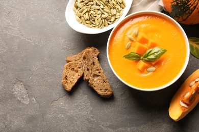 Photo of Flat lay composition with bowl of pumpkin soup on table. Space for text