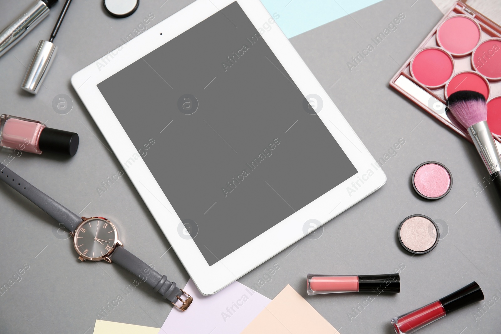 Photo of Composition with tablet and makeup products for woman on grey background