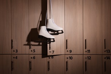 Photo of Ice skater boots hanging on locker door in changing room