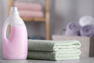 Photo of Folded clean towels and detergent on table in bathroom