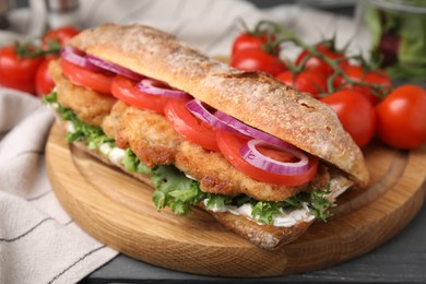 Photo of Delicious sandwich with schnitzel on grey wooden table