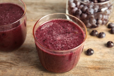 Glasses with delicious acai smoothie on wooden table, closeup