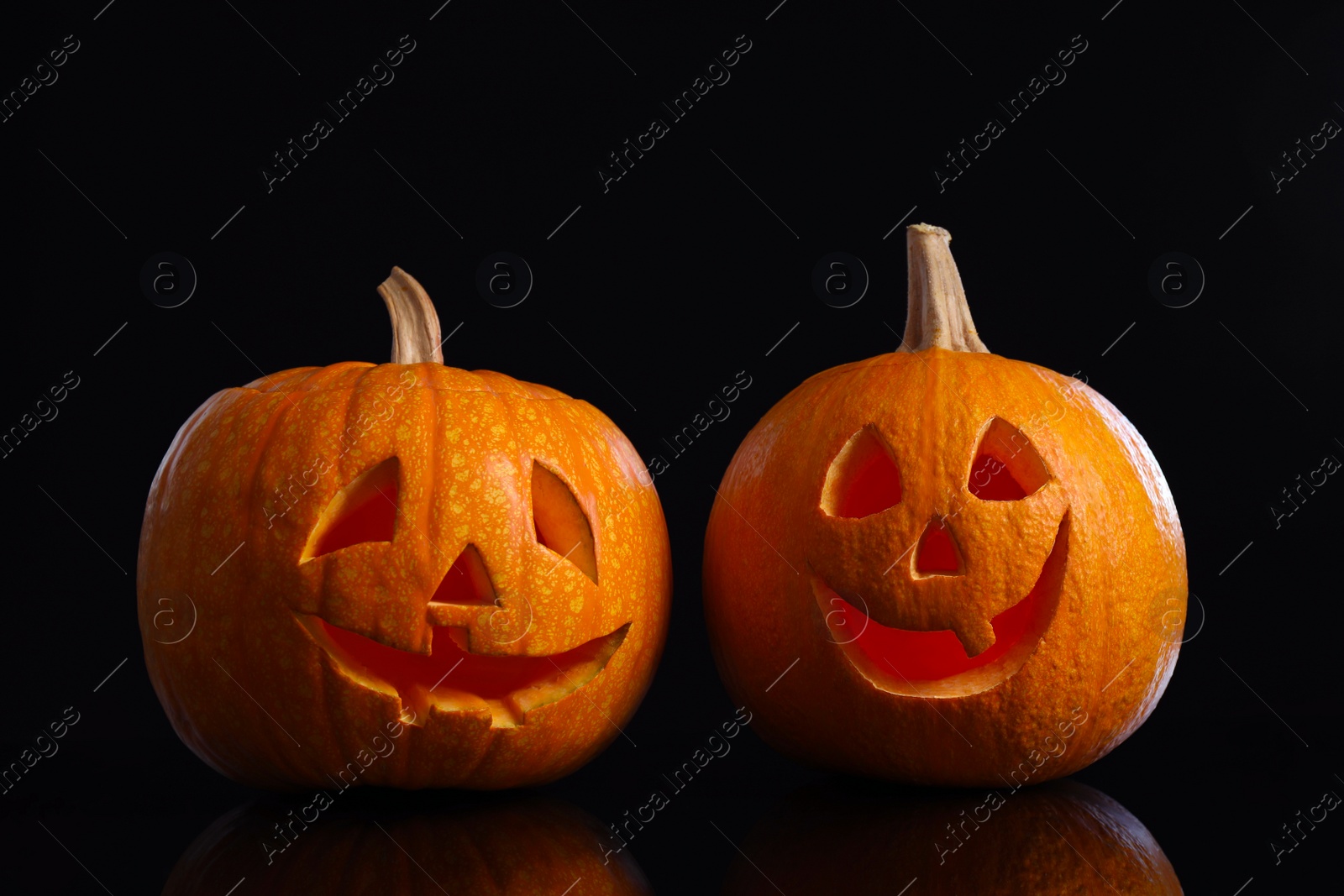 Photo of Pumpkin heads on black background. Jack lantern - traditional Halloween decor