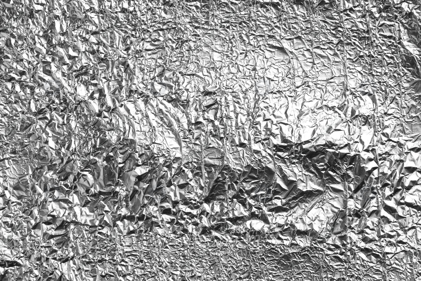 Photo of Crumpled silver foil as background, closeup view