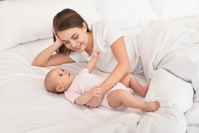 Photo of Portrait of mother with her cute baby lying on bed