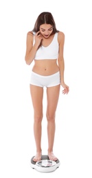 Photo of Slim woman standing on bathroom scale against white background. Weight loss